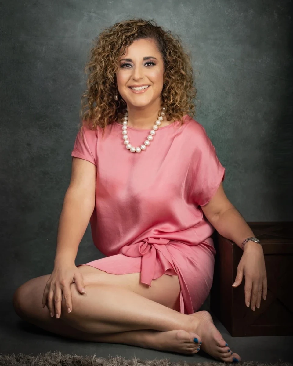Retrato sentado con vestido rosa y collar.