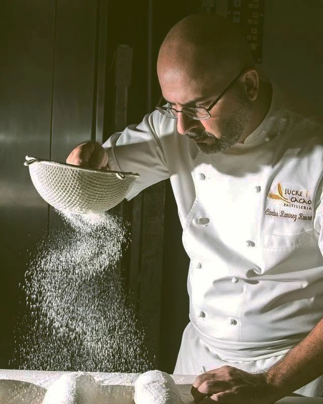 Cocinero tamizando harina con luz lateral.