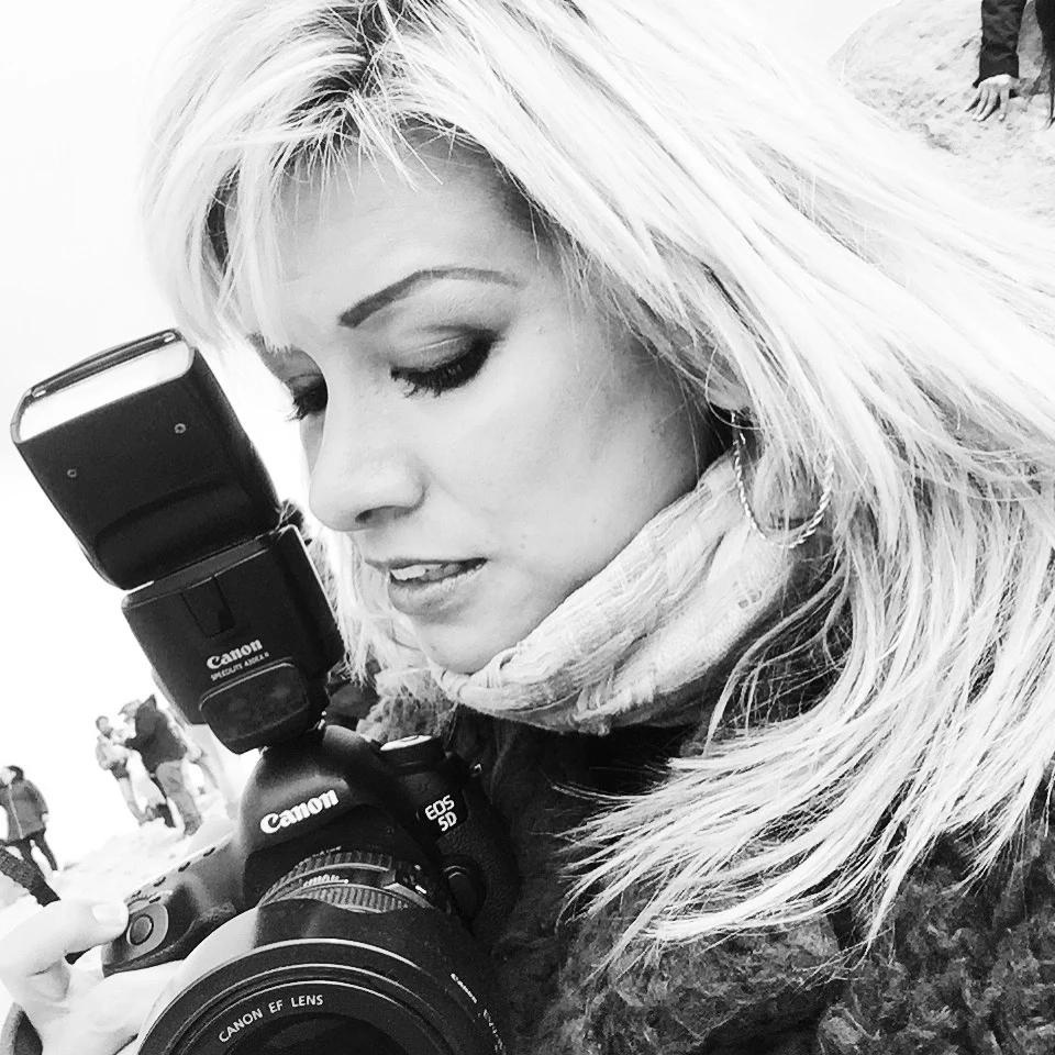 Fotógrafa con cámara en blanco y negro.