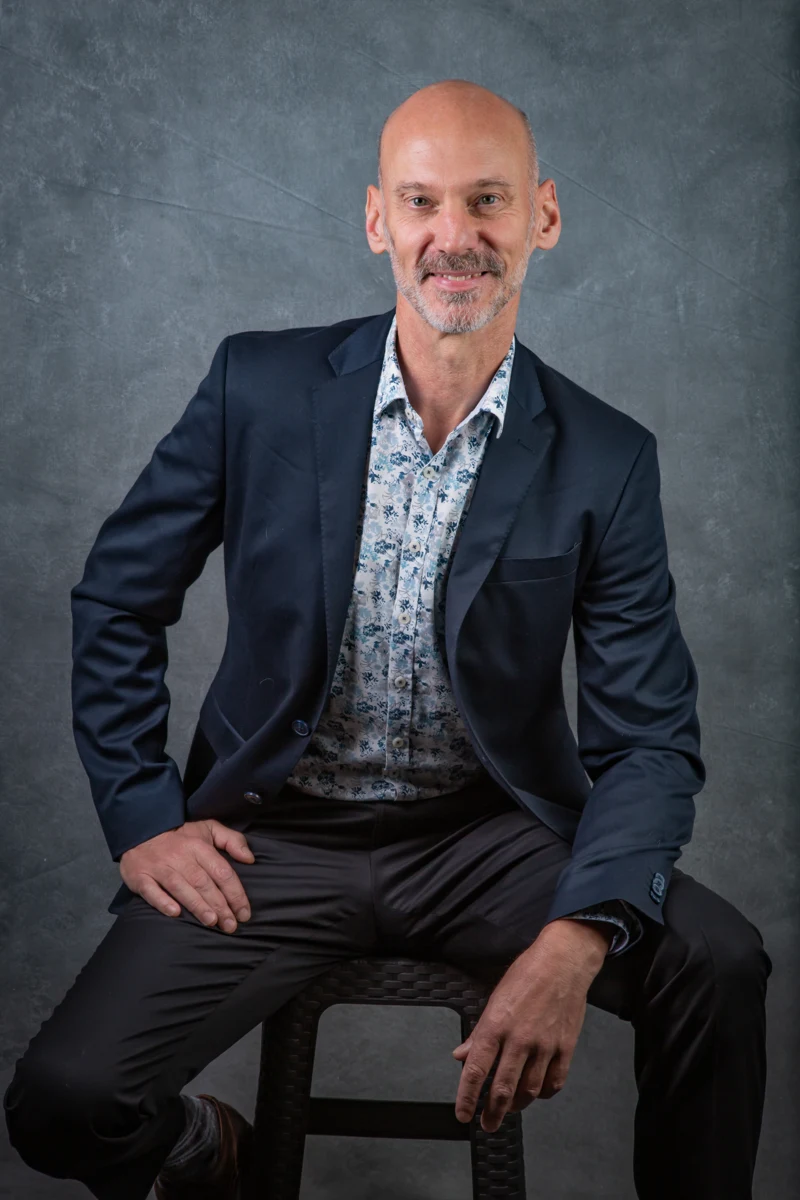 Retrato masculino sentado con traje azul.