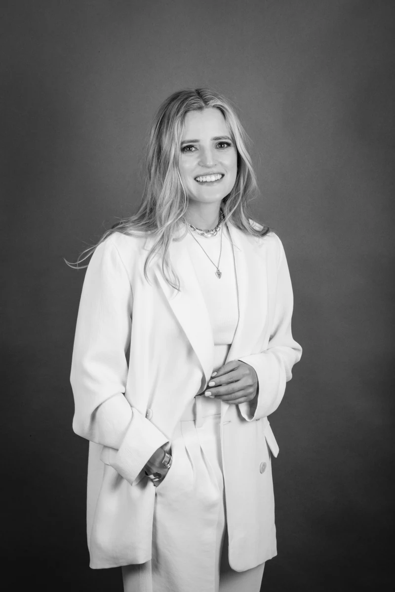 Retrato en blanco y negro con saco blanco.