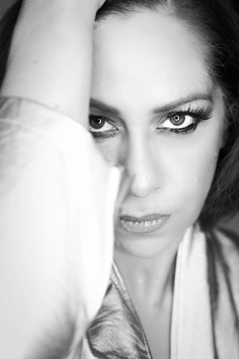 Primer plano en blanco y negro con mano sobre el rostro.