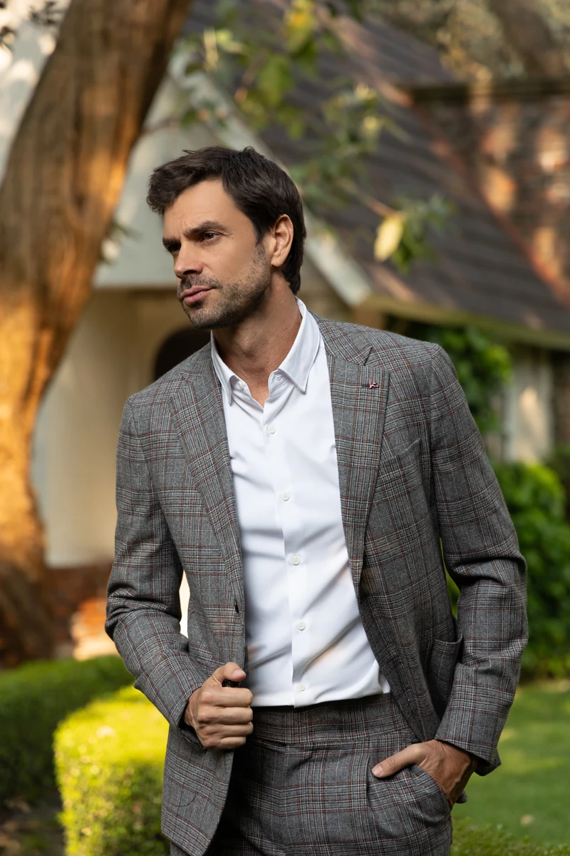Retrato masculino en exterior con traje gris.